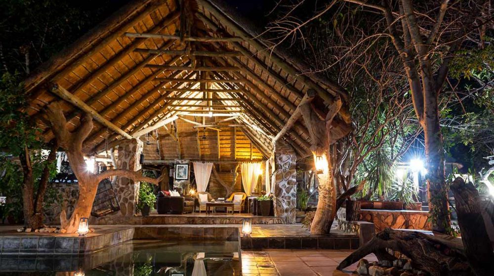 La piscine et le salon la nuit