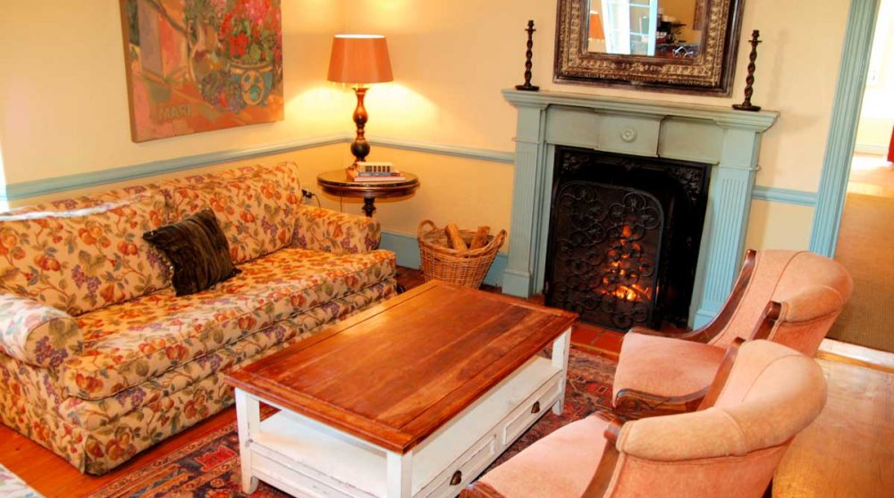 Un salon avec une cheminée à Franschooek