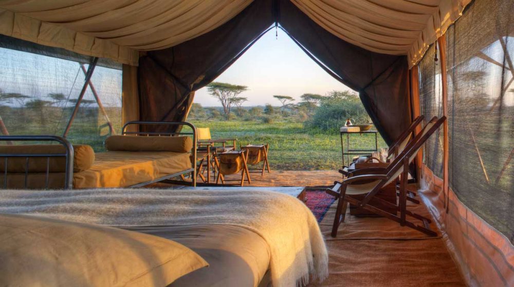 Une tente avec un lit auSerengeti Under Canvas