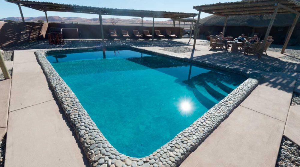 La grande piscine avec des chaises longues en Namibie