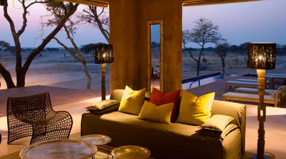 Vue nocturne du salon de l'Onguma Fort Lodge