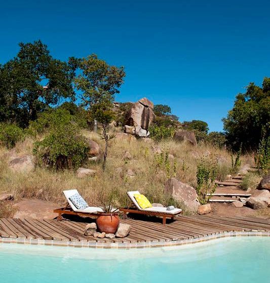 Chaises longues au bord de la piscine dans le parc du Seregenti