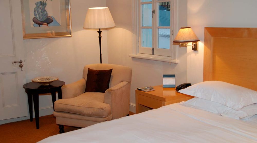 Fautueil et lit dans une chambre au Cap