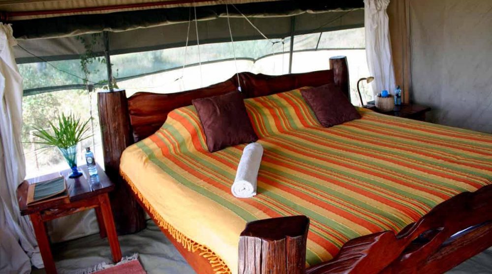 Un grand lit dans une tente au Kenya