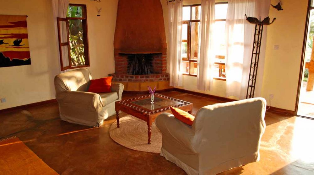 Cheminée et fauteuils dans une chambre au Ngorongoro Farm House